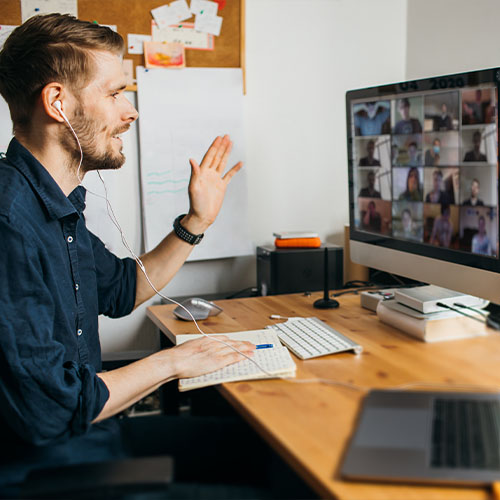 Medarbejde foran skærm deltager i en online møde.