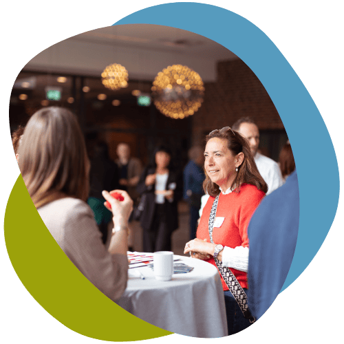 Konferencedeltagere taler sammen ved højbord